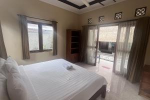 a bedroom with a white bed and two windows at Rama Garden Lembongan in Nusa Lembongan +47 photos