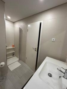 a white bathroom with a shower and a sink at Pereira Azuara in Póvoa de Varzim