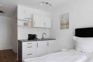 ein Schlafzimmer mit weißen Schränken, einem Waschbecken und einem Bett in der Unterkunft Ferienwohnung Juliette,sehr zentral in Freiburg im Breisgau + 22 Fotos