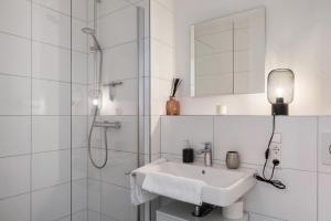 ein weißes Badezimmer mit Waschbecken und Dusche in der Unterkunft Ferienwohnung Juliette,sehr zentral in Freiburg im Breisgau