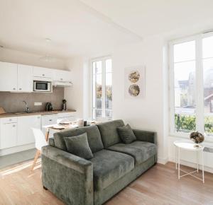 a living room with a couch and a kitchen at PARISIAN ROMANTIC - 4 Pers - Wifi in Chatou
