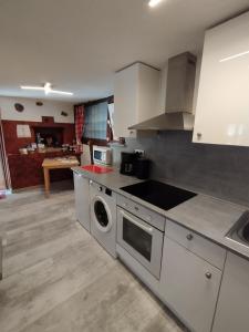 a kitchen with a sink and a stove top oven at Gite Anne & Jean-Paul in Cleebourg +5 photos