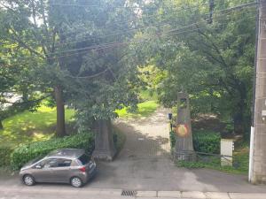 a car parked next to a gate in a driveway at Douce Mathilde in Aywaille