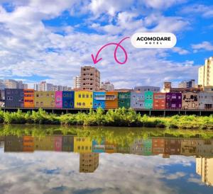 Una vista de una ciudad con un reflejo en el agua. en ACOMODARE HOTEL- SOB NOVA Direção, en Tubarão
