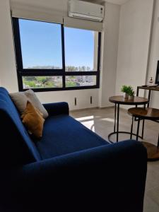 サンフアンにあるDepto Alem y Central RFの大きな窓付きのリビングルーム(青いソファ付)
