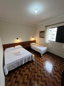 a hotel room with two beds and a window at ACOMODARE HOTEL- SOB NOVA Direção in Tubarão +23 photos