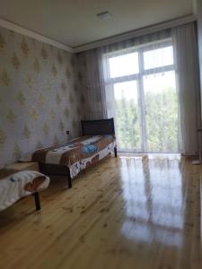 a bedroom with two beds and a large window at TamoLand in Astara