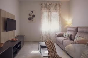 a living room with a couch and a tv at Apartamento Urbano Granada in Granada