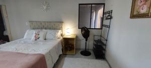 a bedroom with a white bed and a mirror at Loft espaçoso e confortável in Três Marias