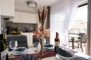 a dining room table with wine bottles and glasses at Villa Full Moon Luxury Apartments Novalja in Novalja