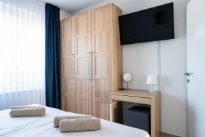 a bedroom with a bed and a tv on a wall at Villa Full Moon Luxury Apartments Novalja in Novalja