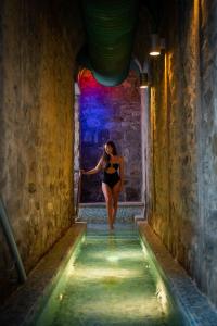 a woman in a black dress walking down a tunnel at Hotel Helvetia Thermal SPA 4s in Porretta Terme
