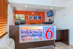 a television in a room with an orange wall at Motel 6-Phoenix, AZ - Airport - 24th Street in Phoenix