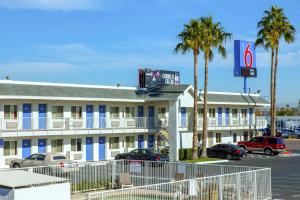 un hotel con palme di fronte a un parcheggio di Motel 6-Phoenix, AZ - Airport - 24th Street a Phoenix