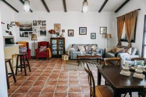ein Wohnzimmer mit Sofas und einem Tisch und Stühlen in der Unterkunft Fantástica casa con piscina Carmona Sevilla in Brenes