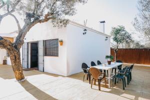 eine Terrasse mit Tisch und Stühlen und einem Baum in der Unterkunft Fantástica casa con piscina Carmona Sevilla in Brenes