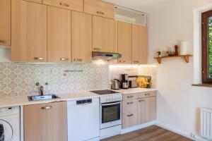 a kitchen with white appliances and wooden cabinets at Ferienhaus Birnberg in Leogang +23 photos