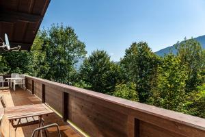 a wooden deck with a table and chairs and trees at Ferienhaus Birnberg in Leogang