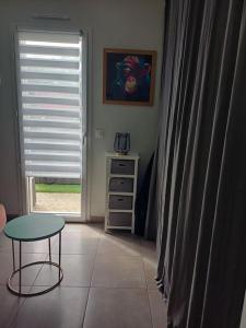 Zimmer mit einem Tisch, einem Tisch und einem Fenster in der Unterkunft Maison individuelle in Neuville-du-Poitou