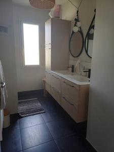 ein Badezimmer mit Waschbecken und Spiegel in der Unterkunft Maison individuelle in Neuville-du-Poitou