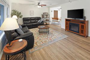 a living room with a leather couch and a fireplace at Adorable Southside ATM Cottage with Bikes, Pets OK in College Station