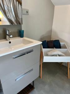 a bathroom with a sink and a couch at Appartement Remparts de Guérande in Guérande