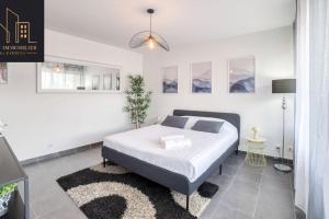 a white bedroom with a bed and a rug at Appartement City Mountain in Cluses +6 photos