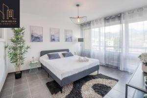a bedroom with a bed and a large window at Appartement City Mountain in Cluses