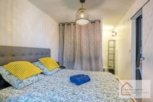 a bedroom with a bed with yellow and blue pillows at Escapade paisible 2 à 4 voyageurs in Monplaisir +2 photos