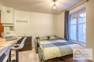 a bedroom with a bed and a desk and a window at Escapade paisible 2 à 4 voyageurs in Monplaisir