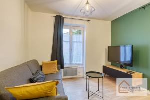 a living room with a couch and a tv at Escapade paisible 2 à 4 voyageurs in Monplaisir
