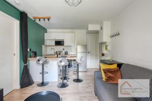 a living room with a couch and a kitchen at Escapade paisible 2 à 4 voyageurs in Monplaisir