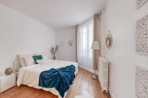 a white bedroom with a bed and a window at Oh Parisien à 10 min de Paris Montparnasse in Vanves