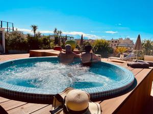 two people in a swimming pool on a patio at Best Western Premier Le Patio des Artistes Wellness Jacuzzi in Cannes