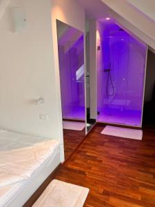 een paarse kamer met een bed en een spiegel bij Penthousetraum im Herzen Merans in Merano