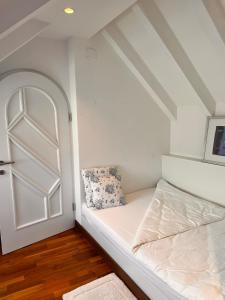 een kleine kamer met een bed en een deur bij Penthousetraum im Herzen Merans in Merano