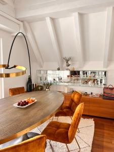 een keuken met een houten tafel en stoelen bij Penthousetraum im Herzen Merans in Merano
