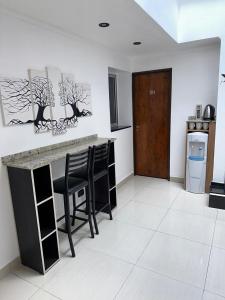 a kitchen with a counter and stools in a room at Hotel Quito in Buenos Aires +18 photos