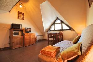 a room with a bed and a microwave and a table at Studio duplex au pied des pistes in Laveissière