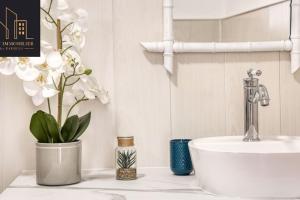 a white bathroom with a sink and a white sink at Appartement Pastel in Cluses +4 photos