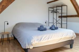 une chambre avec un lit avec des serviettes bleues dessus dans l'établissement 'Maison Lison' le Calme en ville, à Annoeullin