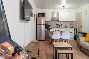 une cuisine et un salon avec une table et des chaises dans l'établissement 'Maison Lison' le Calme en ville, à Annoeullin