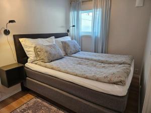a large bed in a bedroom with a window at 1 bedroom apt with parking in Kvaløya
