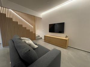 a living room with a couch and a flat screen tv at Amarina - appartamento boutique sul mare in Marina di Davoli