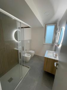 a bathroom with a shower and a toilet and a sink at Amarina - appartamento boutique sul mare in Marina di Davoli