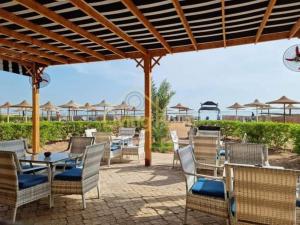 - un ensemble de chaises et de tables avec parasols sur la terrasse dans l'établissement Turtles Beach resort hourghada Studio view sea view pool private beach jacuzzi pools air-conditioned restaurant on the beach jacuzzi security and a large sunny balcony, à Hurghada
