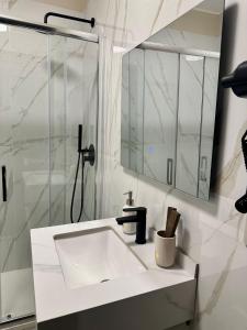 a white bathroom with a sink and a mirror at Golden Palm B&B in Bari