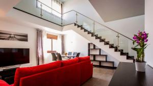 ein Wohnzimmer mit einem roten Sofa und einer Treppe in der Unterkunft Monte Laguna Duplex - Greice Homes in Estibeira