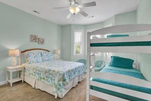 a bedroom with two bunk beds and a bedside table at Pelican Pleasure by Sea Scape Properties in Carolina Beach +31 photos