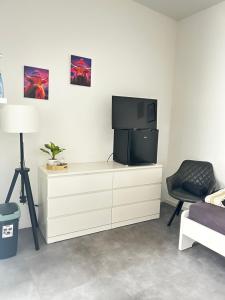 a living room with a tv on a dresser at Apart das Ehrets in Bretzfeld